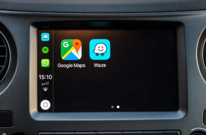 An Apple CarPlay screen on a car dashboard, showing icons for Google Maps and Waze.